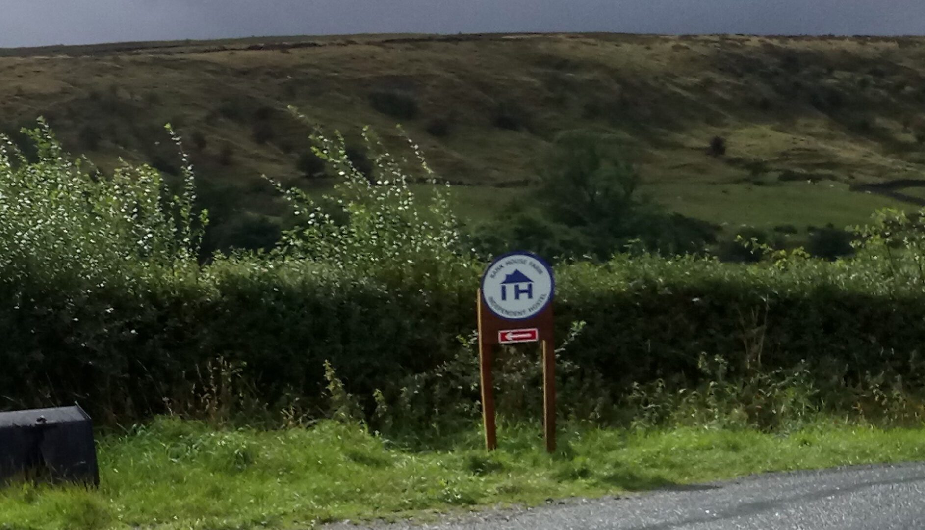 sign to bank house farm with a backdrop of stormy moorland
