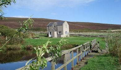 view of rousay hostel with fields in the forground