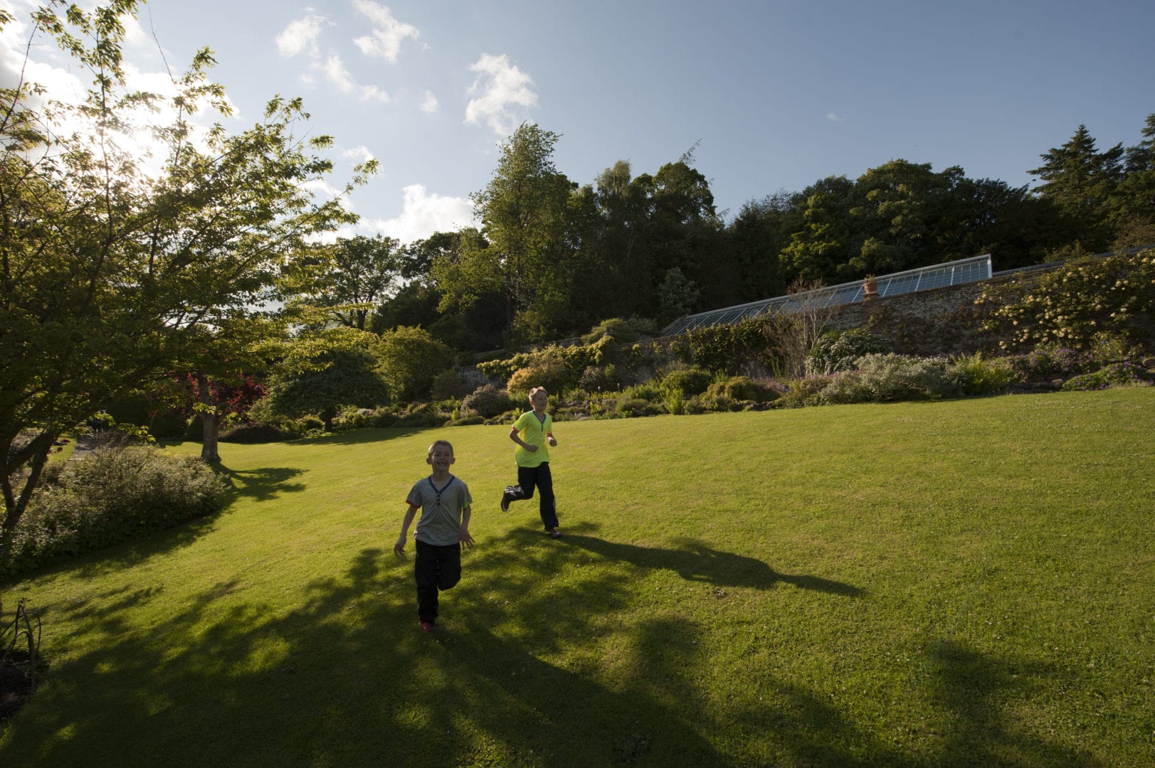 Children playing in the garden at Wallington Bunkhouse, Northumberland.