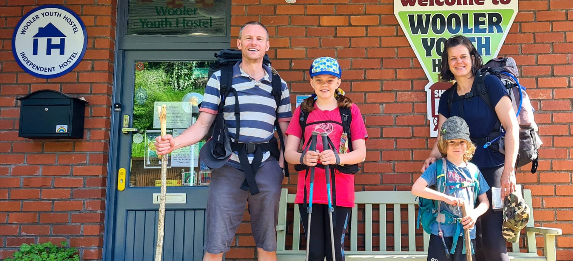family at wooler youth hostel with independent hostels sign