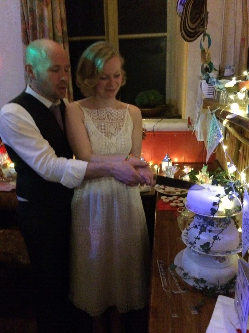 A happy bride and groom cut into their wedding cake