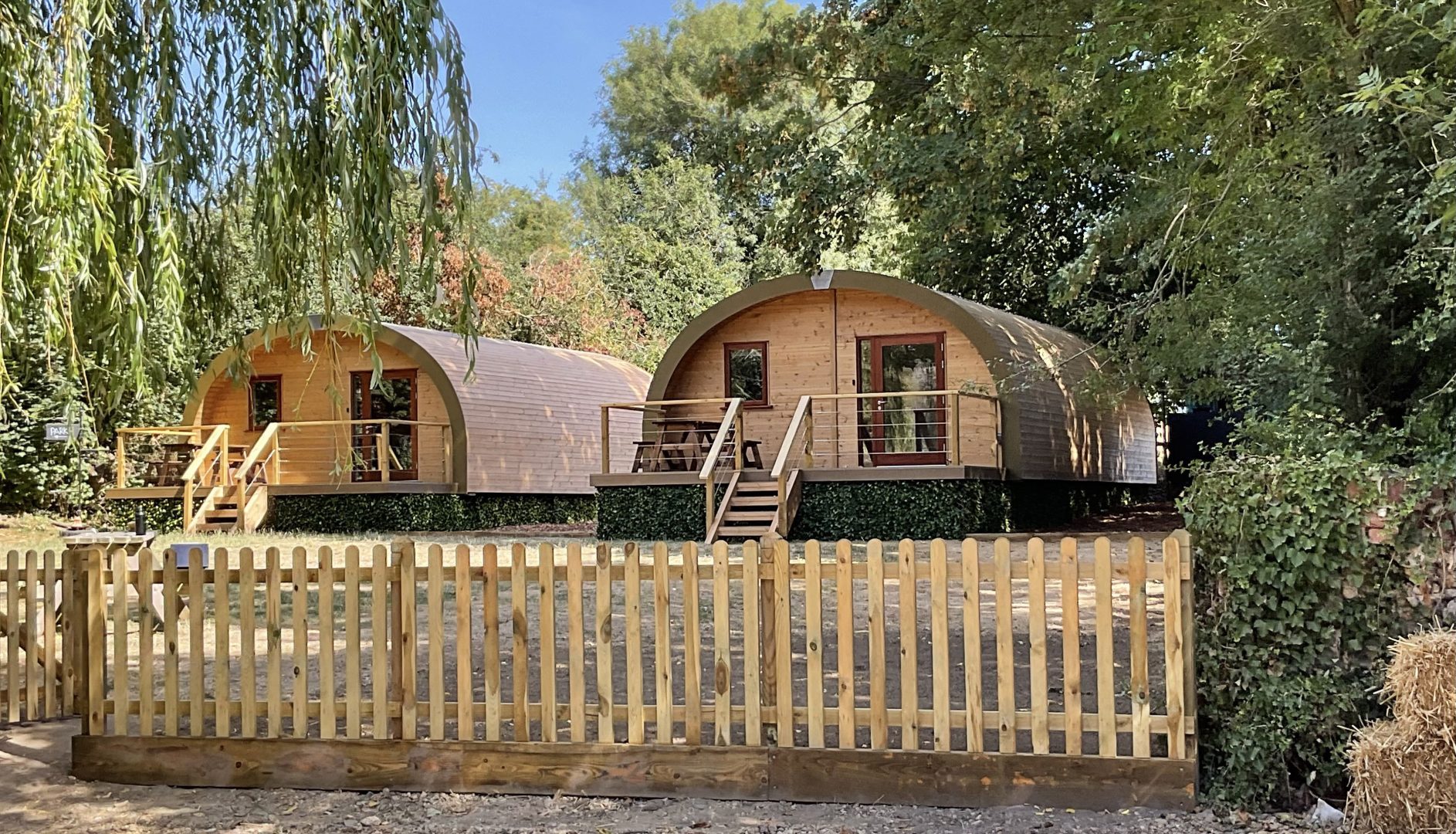 2 wooden calins with picket fence in front