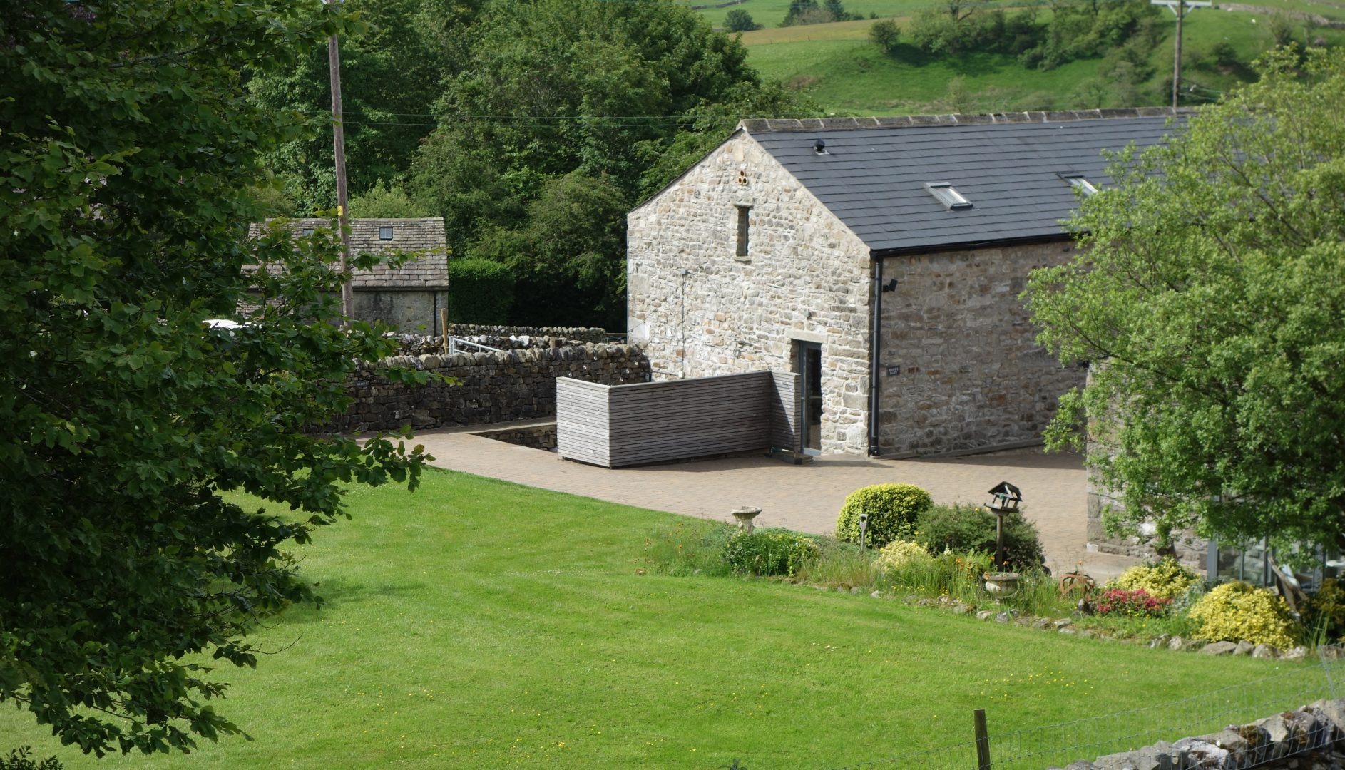 View of the barn with it patio/parking area and grassy lawns