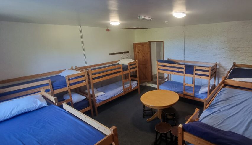 Large dorm room with sturdy wooden bunks
