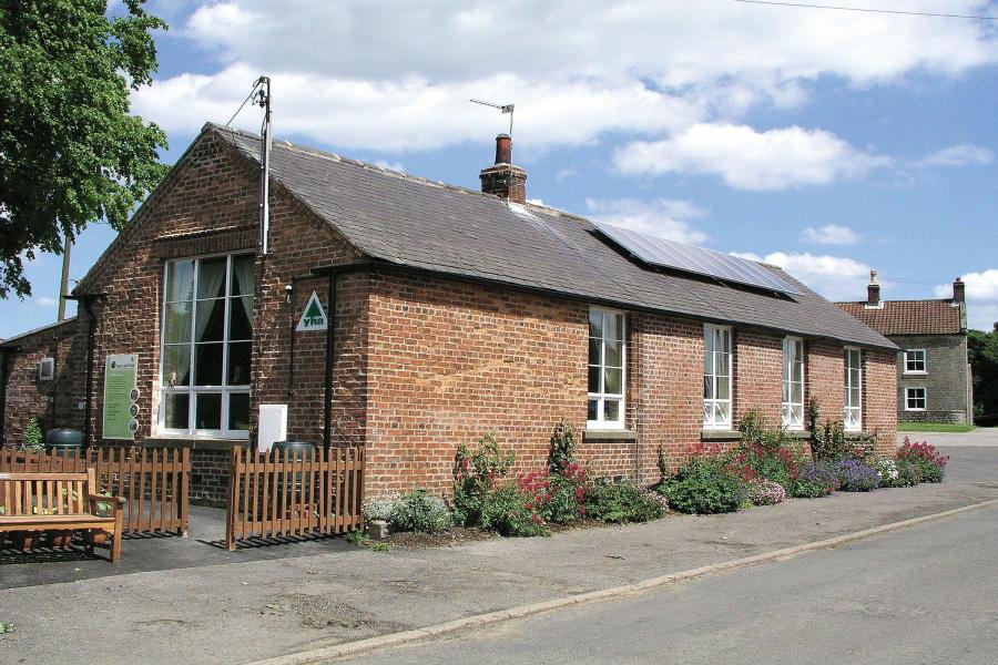 Exterior of red brick former school with solar panels, now a hostel