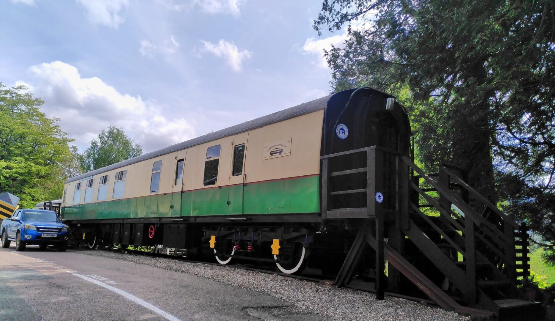 The exterior of the green and cream railway carriage that is now a hostel