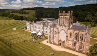 Exterior of the grand buildings of Milton Abbey School with large groups in the grounds