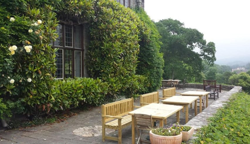 Terrave with tables in front of ivy clad hall