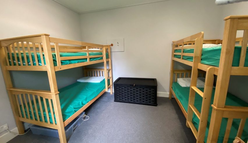$-bed bunkroom with pine beds and green bedding