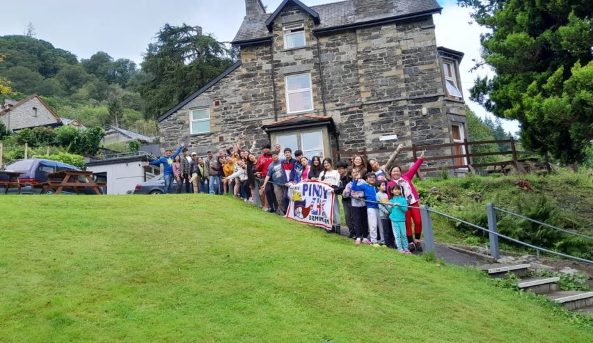 group of happy young people on the steps at the side of the Centre