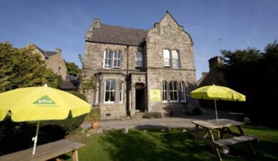 Exterior of stone hostel with YHA branding