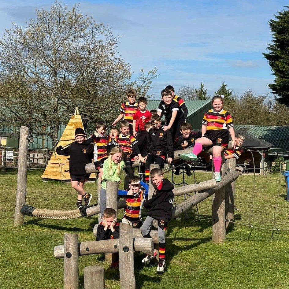 A group of happy children on a climbing obstacle in the grounds of Amelia Trust Bunkhouse