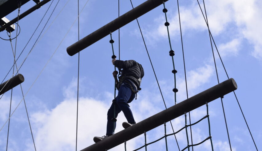 A teenager on the high ropes course at Mount Cook Adventure Centre in the Peak District.