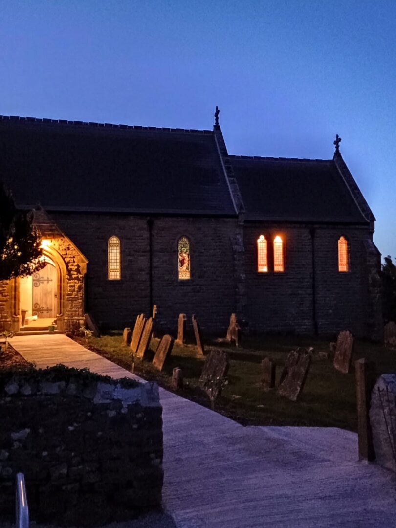 St Michales lodge hostel in a converted church building at niight with light glowing through the windows