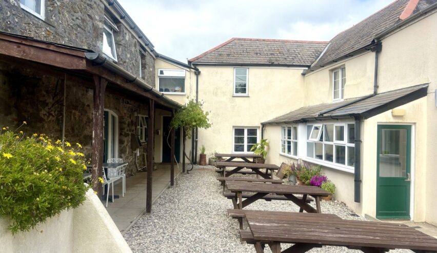 The guests courtyard with picnic tables at Boswinger Youth Hostel (YHA Partner), nr St Austell, Cornwall