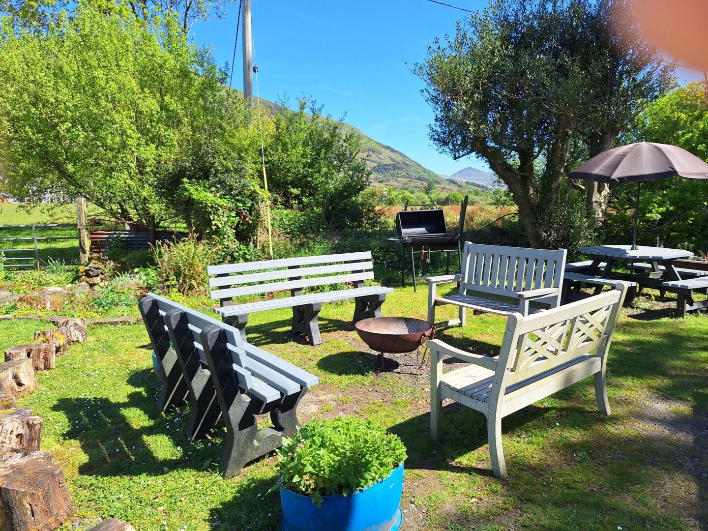 Wooden benches around the fire pit at Pentre Bach Bunkhouse Snowdonia