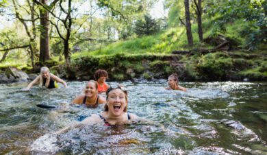 wild swimer laiughing in pool close to independent hostel accommodation