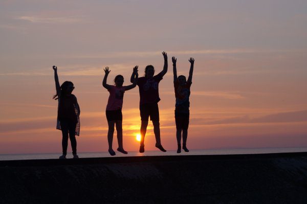 children jumping for joy in the sunset at borth youth hostel