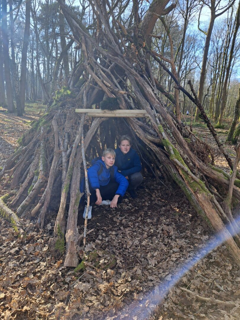 2 children from ucranium school group building a den at hurtwood hostel