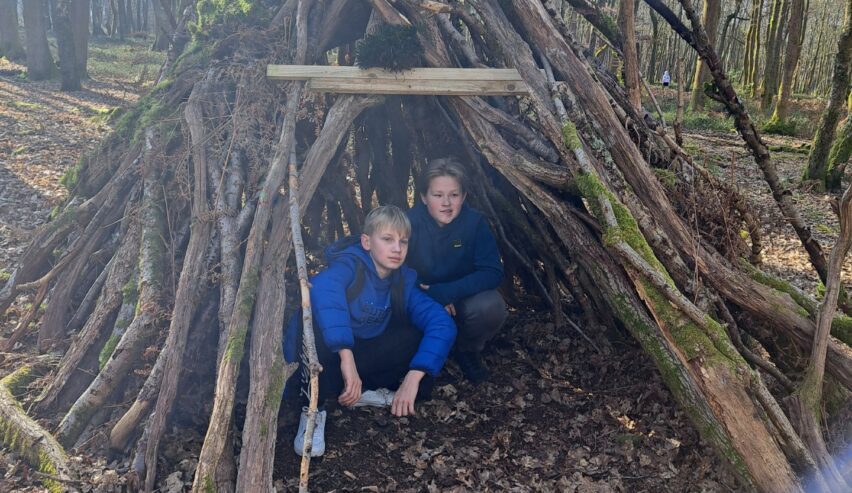 2 children from ucranium school group building a den at hurtwood hostel
