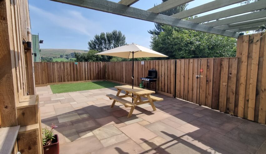 picnic table and bbq in enclosed garden at Roaches Bunkhouse