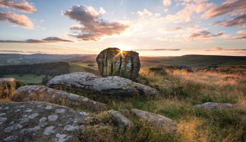 moors over Hathersage showing sunset behind a standing stone