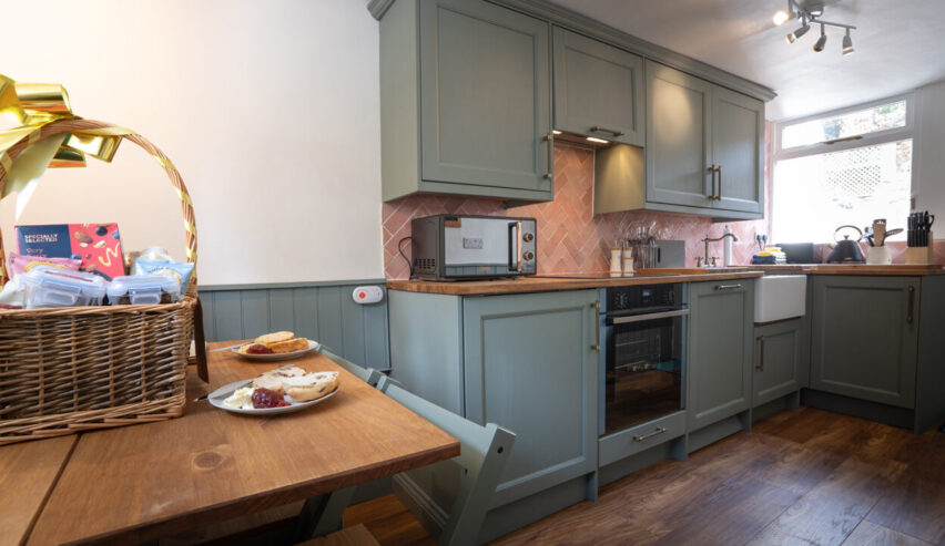 self catering kitchen and tabel showing a cream tea at cosy Cottage in Youlgreave