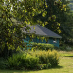 View of Inveraray Hostel in its wooded garden of early autumn