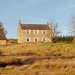 chartners farm hostel showing house on hill with autumn colours and wind turbine