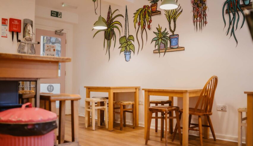 dining room at igloo hostl shows tables and chairs an murials on the wall