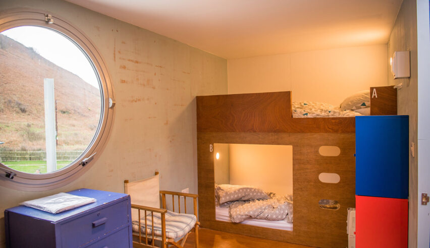 Ty Cwch Boathouse bedroom wqith porthole shared window