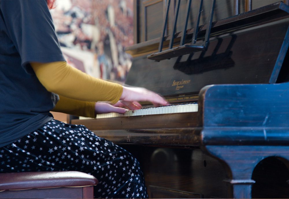 Photograph of Lily's hands playing the keys on the piano.