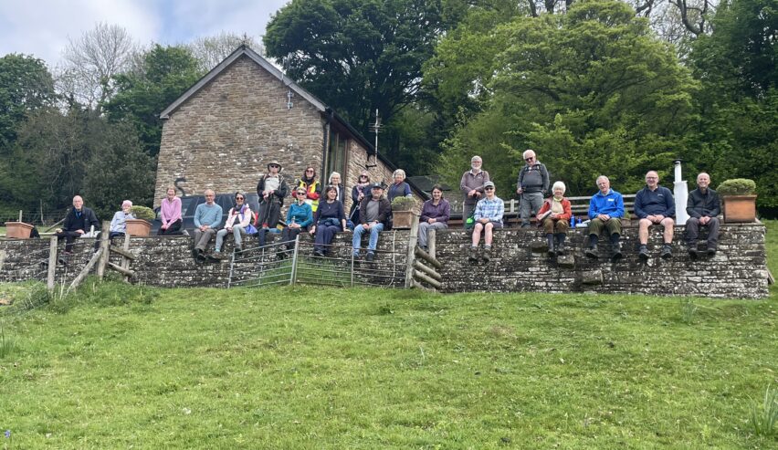 walkers sat on a wall taking prt in chepstow walking festival