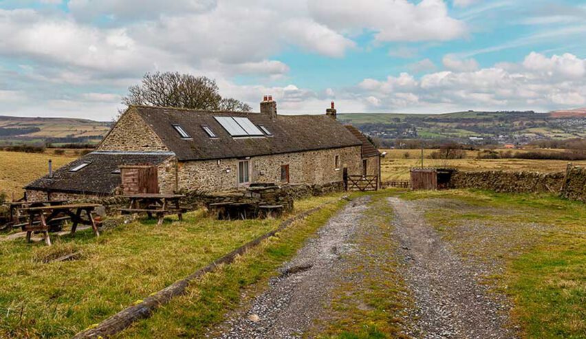 Carrs Farm Bunkhouse with blue skye and a backdrop of moorland