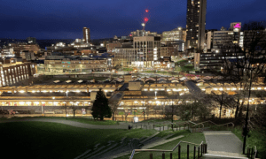 Sheffield city at night under a glowing navy sky, with the first hints of dawn appearing. 