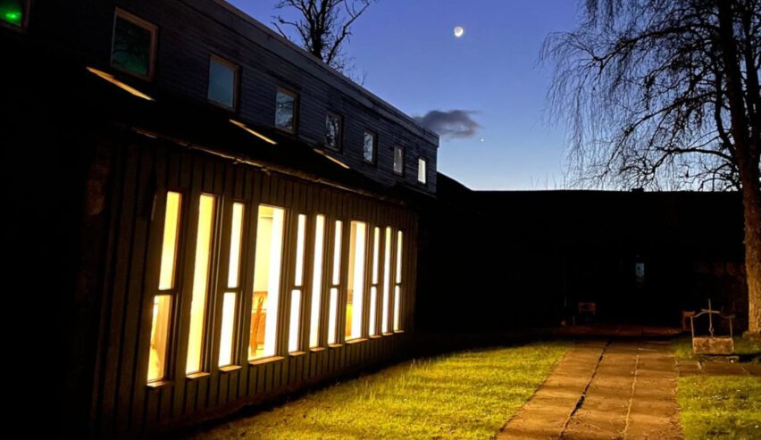nightime scene at Kindrogan House with moon and light through the windows