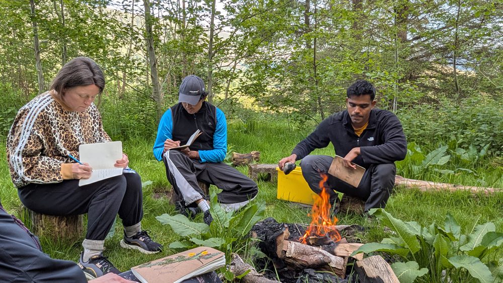 wellbeing retreat participants socialing around the campfire