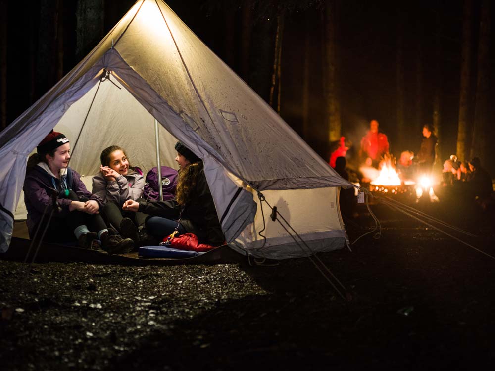 three female scouts in a tent