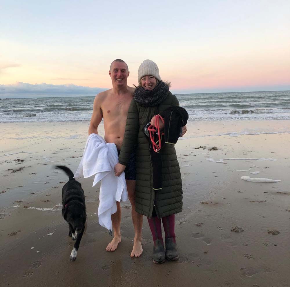couple just after sea swiming on the beach with dog